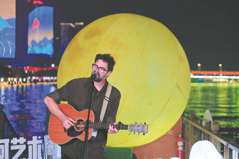 Pekin Uluslararası Kanal Sanat Festivali kapsamında Büyük Kanal kıyısında gitarıyla sahne alan müzisyen