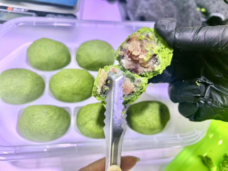 Plastik kutuda yeşil matcha mooncakeler ve içi Yunnan jambonlu dolgusu görünen parça.