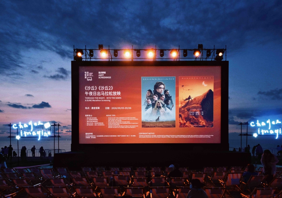 Akşam gökyüzü önünde açık havada büyük bir film ekranı ve boş izleyici koltukları.