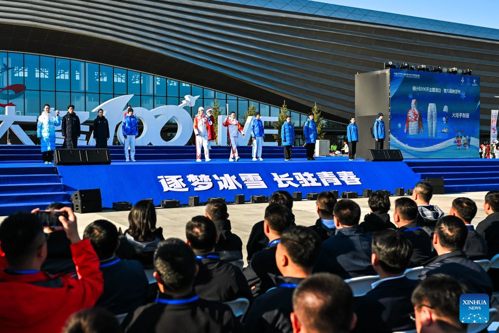 Changchun’da meşale ve madalyanın tanıtıldığı törende sporcular ve izleyiciler sahneyi izliyor.