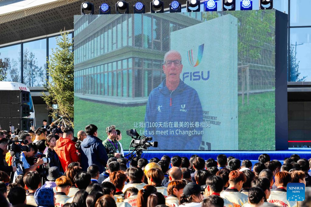 Changchun 2027 Kış Üniversite Oyunları tanıtımında konuşmacı, kalabalık izleyicilere açık hava sahnesinden sesleniyor