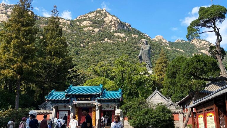 Laoshan Dağı eteklerinde Laozi heykeli, Taiqing Sarayı ve ziyaretçiler görülüyor