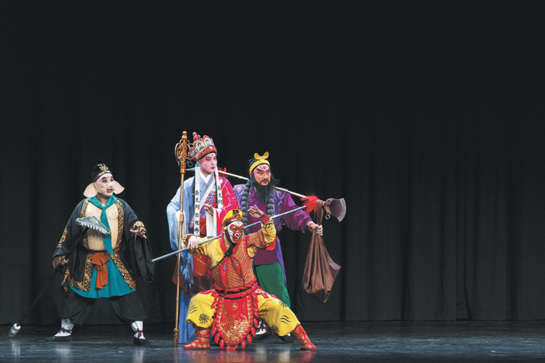 Wu operası sanatçıları renkli geleneksel kostümlerle sahnede dramatik bir performans sergiliyor